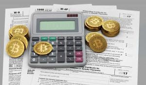 Skatteskjemaer under en kalkulator og gyldne Bitcoins