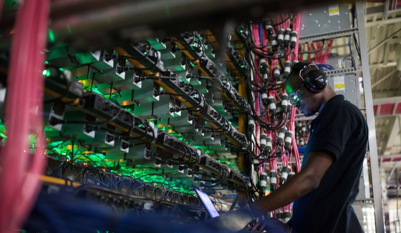 En tekniker övervakar gruvbrytningsriggar cryptocurrency på en Bitfarms-anläggning i Saint-Hyacinthe, Quebec, Kanada, i juli 2018. Foto: Bloomberg