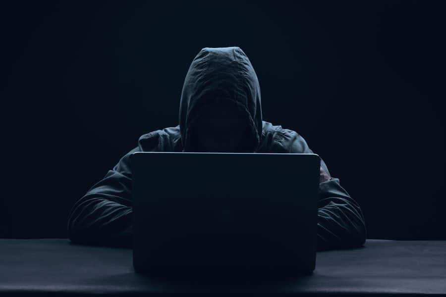 Hooded hacker at computer