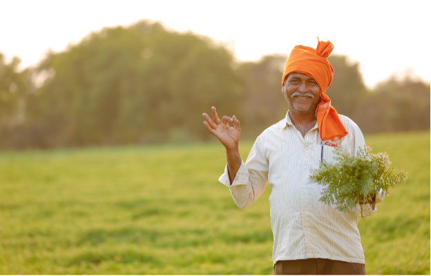 Naeratav mees hoiab käes taime