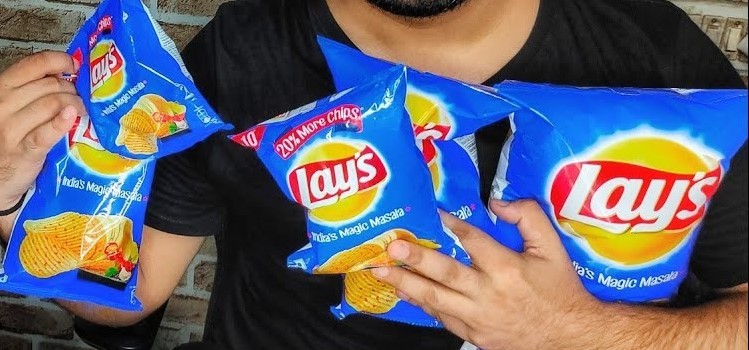 man holding packets of blue lays potato chips