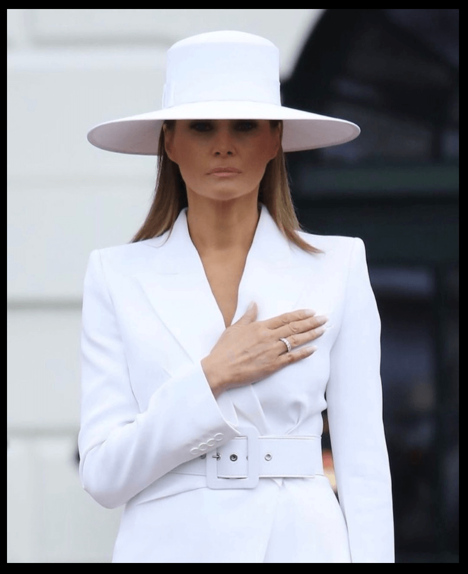 Білий широкополі, високий коронний капелюх, який носила та підписала Меланія Трамп (Ерве П’єр, 2018)