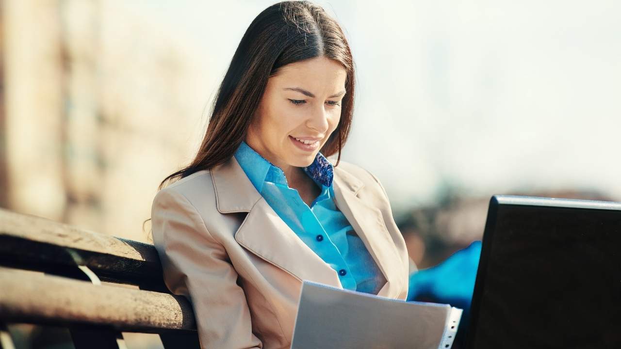 Happy brunettte businesswoman leader using laptop in the park