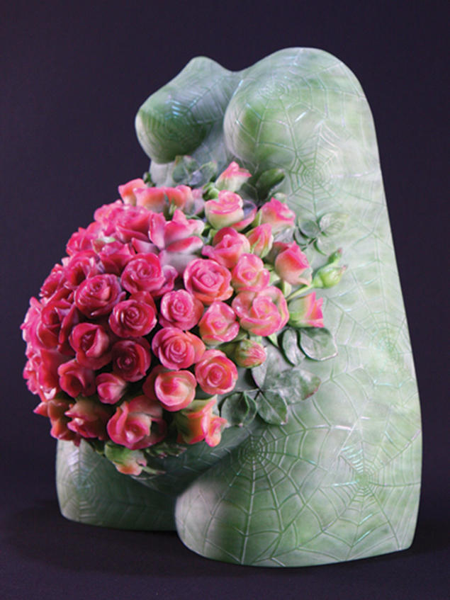 Szklana sztuka przedstawiająca tors człowieka ozdobiona różowymi kwiatami