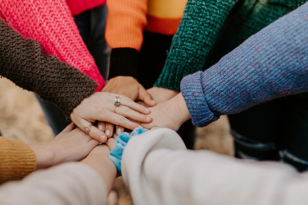 a group of people with their hands piled together. 