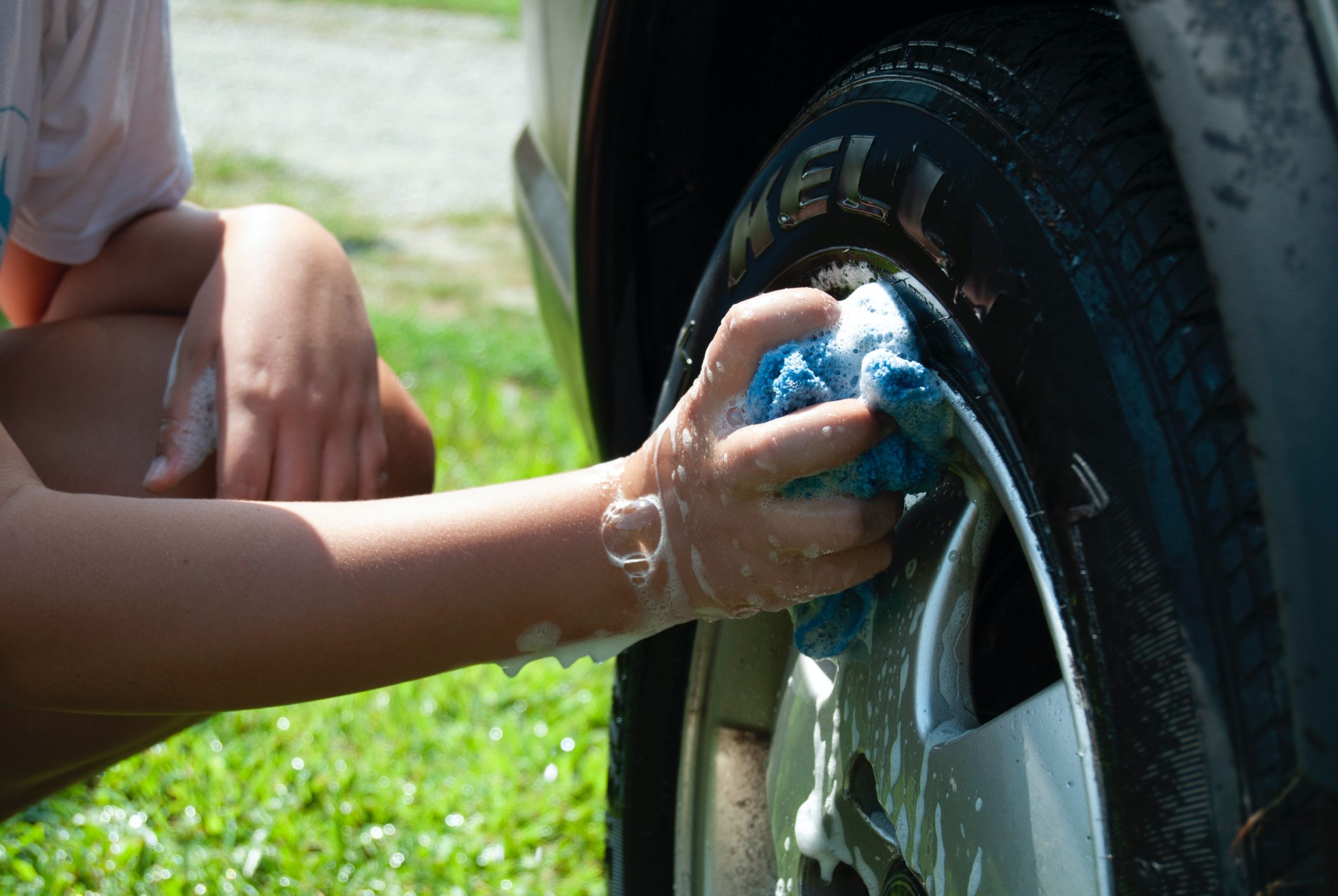 Omul care spăla mașina de mână o parte dintr-o spălătorie auto, o strângere de fonduri bună pentru clubul de stimulare