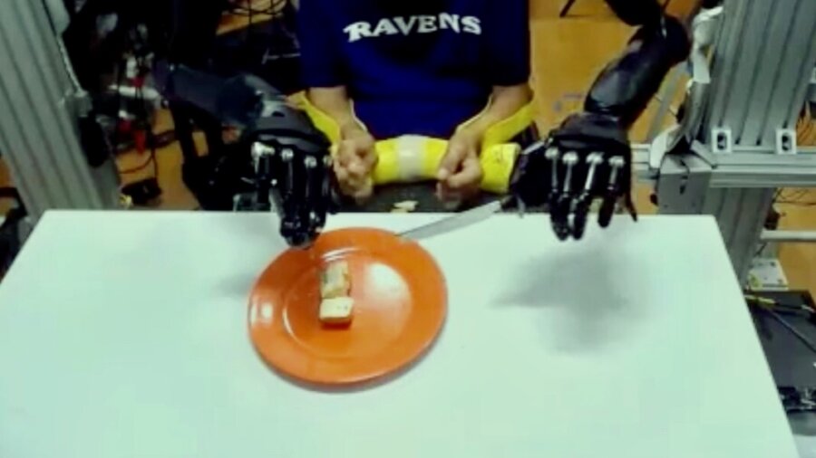 Halvautunut mies käytti mieltään hallitakseen kahta robottikäsivartta syödäkseen kakkua PlatoBlockchain Data Intelligencesta. Pystysuuntainen haku. Ai.