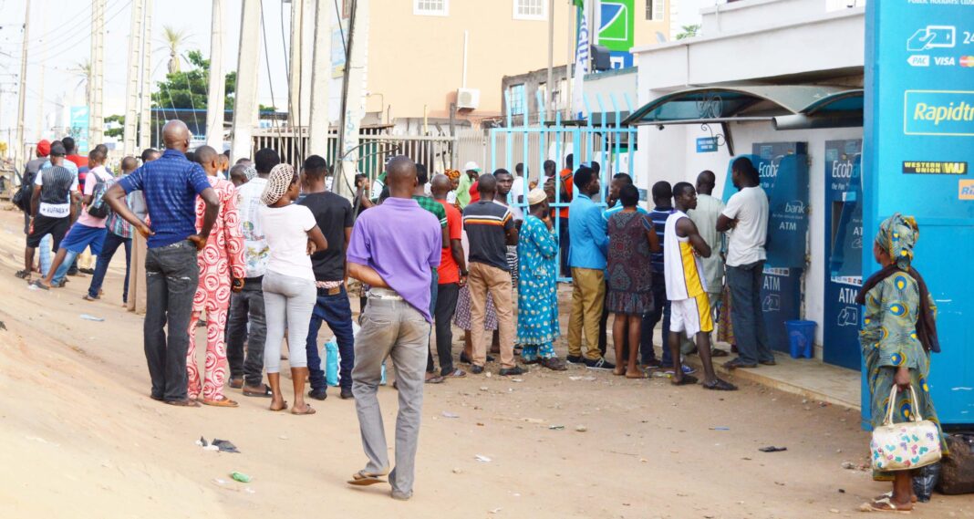 Nigerians queue to receive cash in banks. 