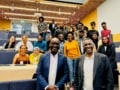 Фотографія Марка Річардса та Вашингтона Очіенга разом із великою групою темношкірих фізиків у лекційному залі