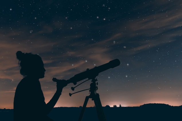 Women with astronomical telescope