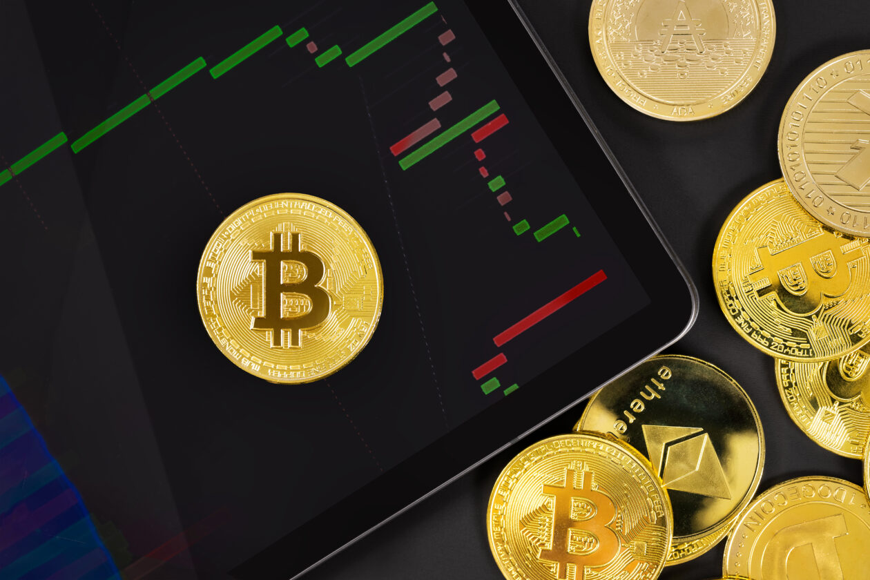 Bitcoin บนแผ่นดิจิตัลพร้อมกราฟแลกเปลี่ยนโดยเหรียญ crypto