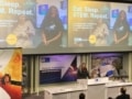 Anne-Marie Imafidon przemawia na konferencji kosmicznej w Appleton, pod ekranem pokazującym zdjęcia uśmiechniętych młodych kobiet i napis „Jedz. Śpij. STEM. Powtórz”