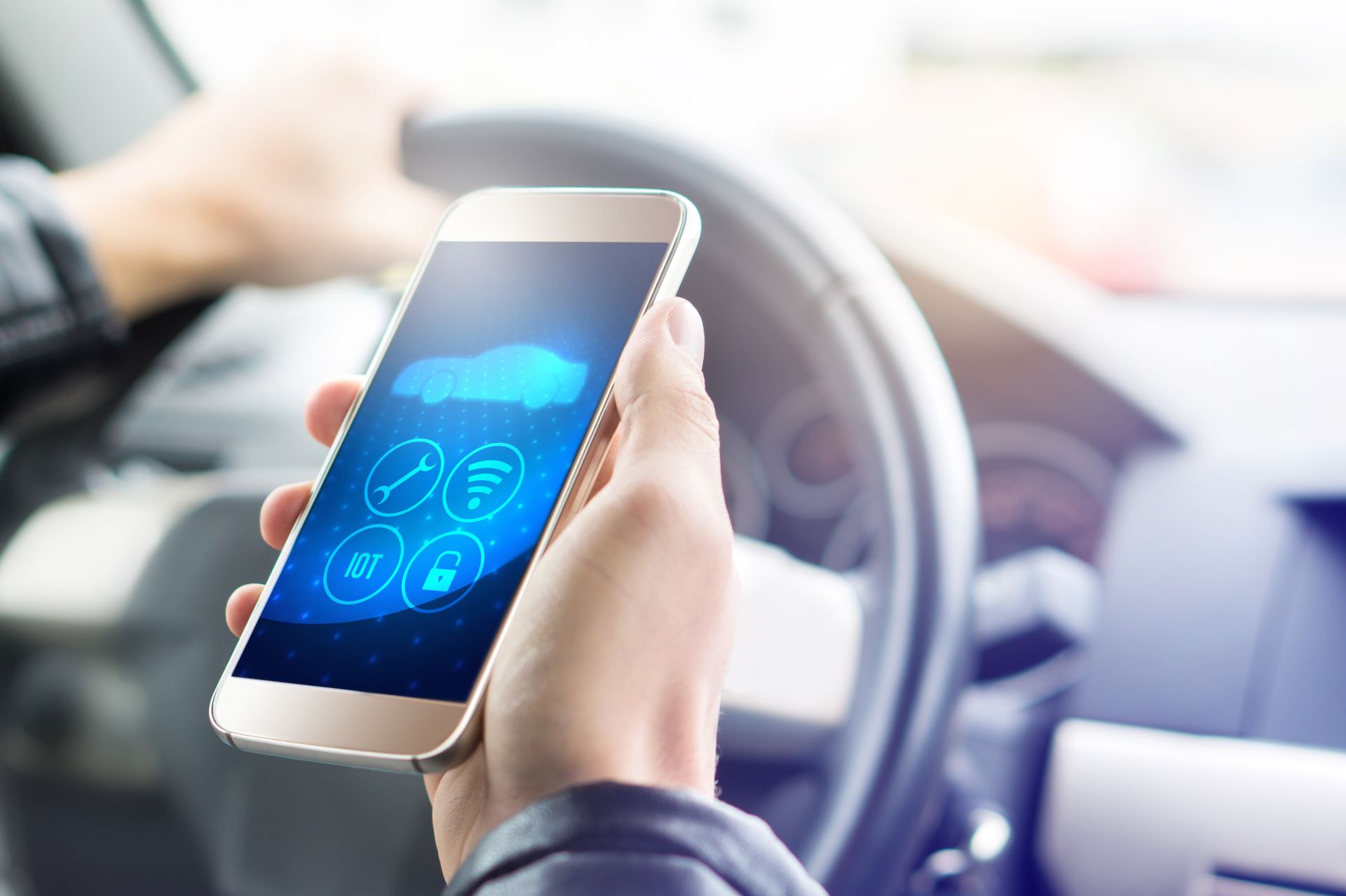 Смартфон в автомобиле, на котором установлено приложение для умного автомобиля.