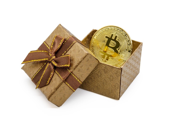 สัญลักษณ์ bitcoin บนเหรียญทองในกล่องของขวัญทองคำ