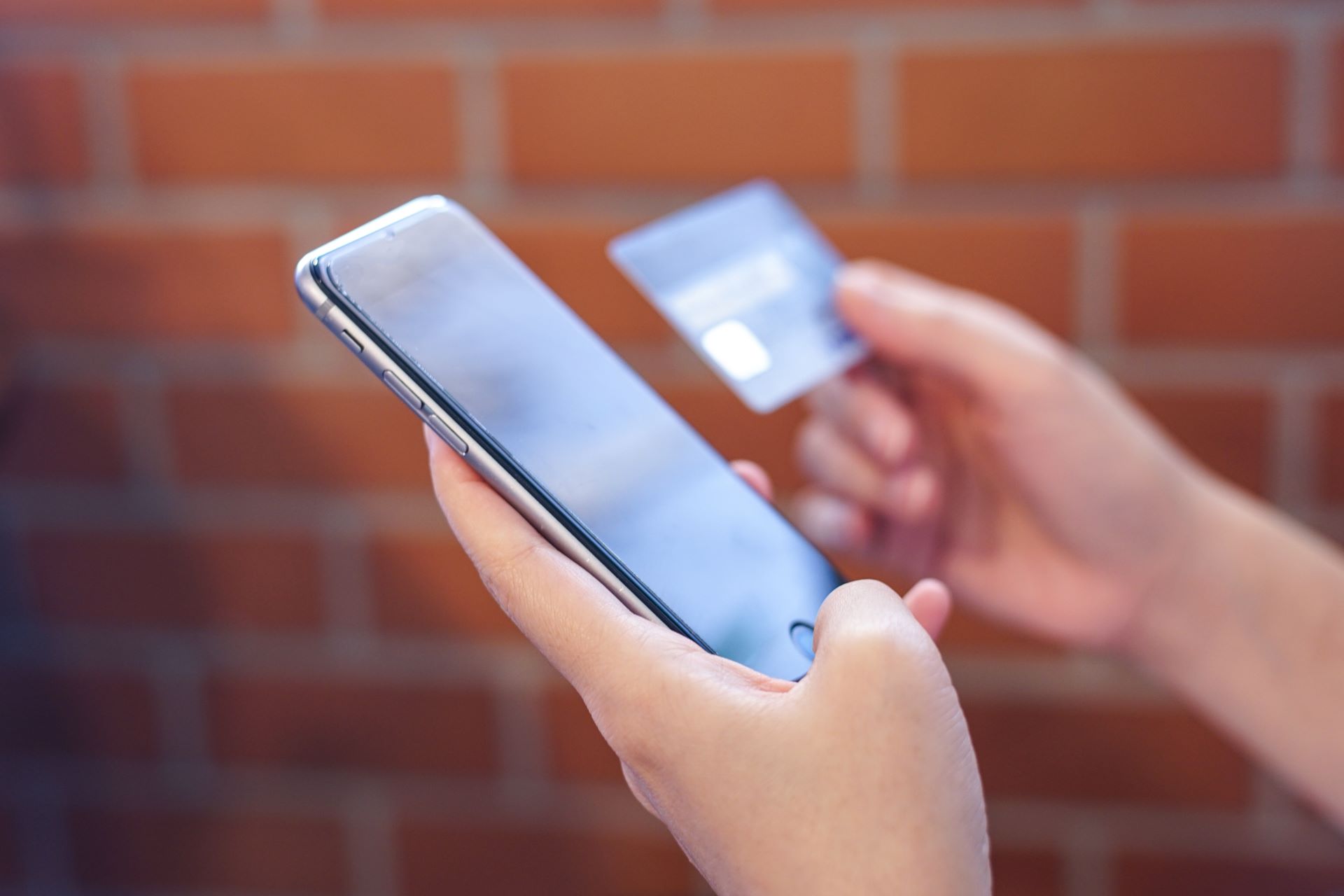 Iphone ve bir elde birbirine yakın tutulan bir kart